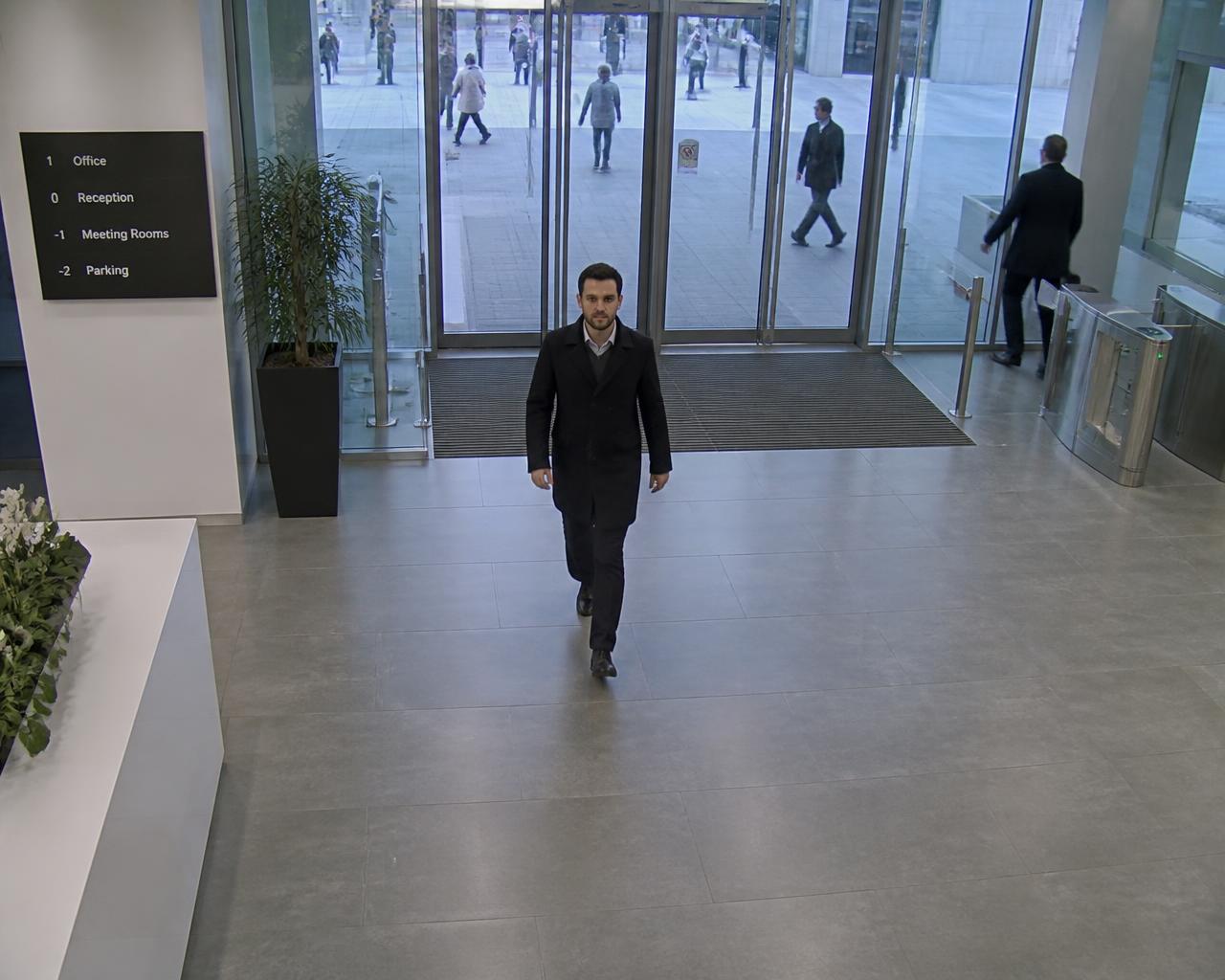 Man entering an office building through the main entrance, his face detected by Viante