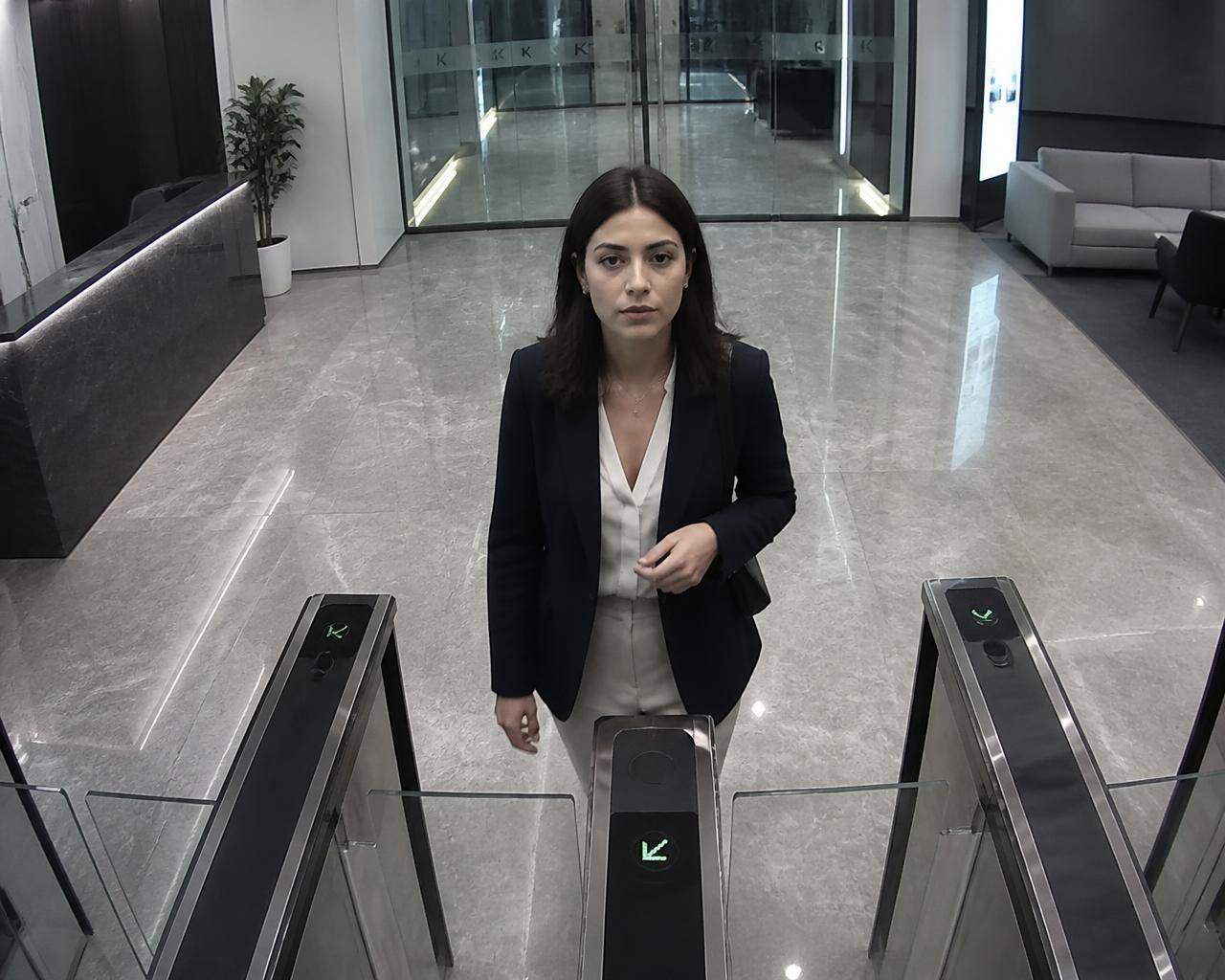 Woman approaching a corporate lobby turnstile with her identity verified by Viante